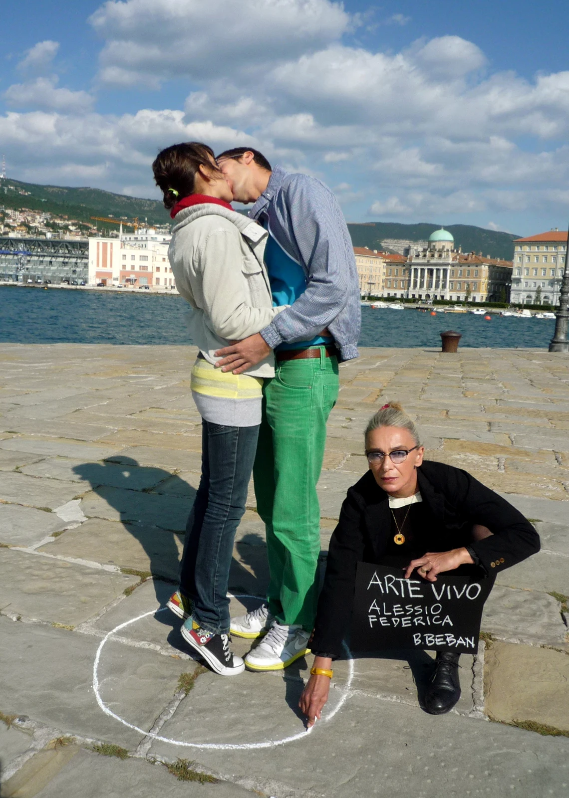 Breda Beban, Arte Vivo, series of photographs, 2008–2011: a couple kissing by the waterfront beside a woman holding an Arte Vivo sign.